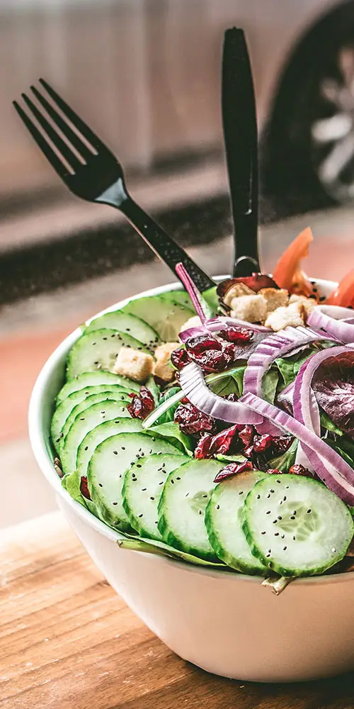 Healthy salad bowl with cucumbers, onions, and greens – promoting balanced nutrition and wellness